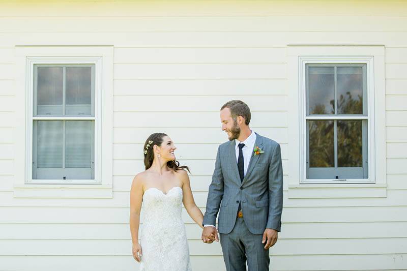 A couple stands in front of a yellow wall at their diy mountain wedding in Colorado.