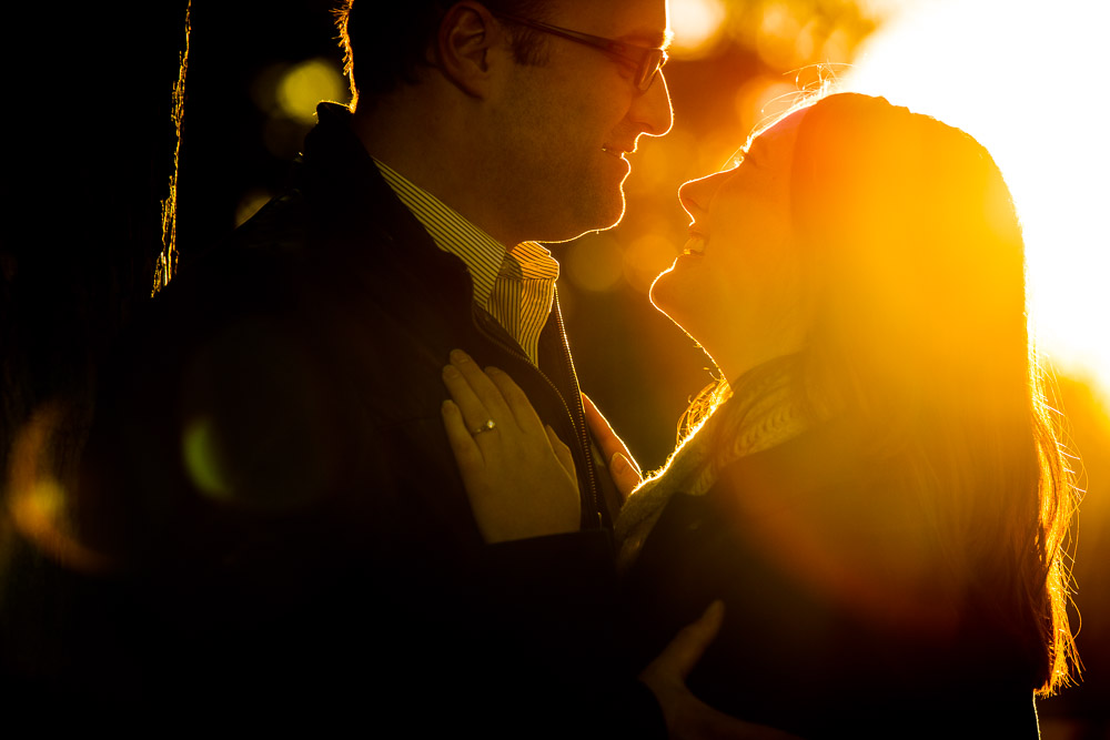 A couple with their arms around eachother at sunset during their Denver outdoor Engagement session at Cheesman Park.